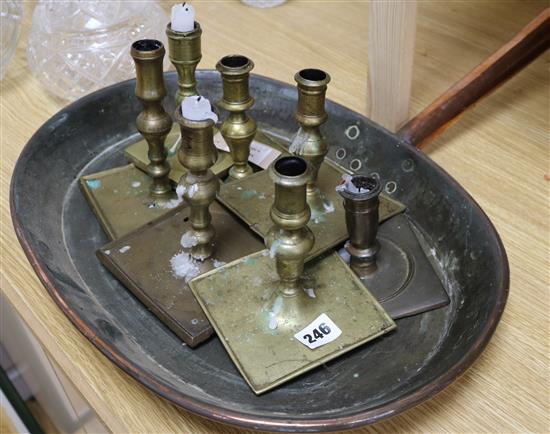 A collection of seven assorted square base candlesticks and a large copper pan (8)